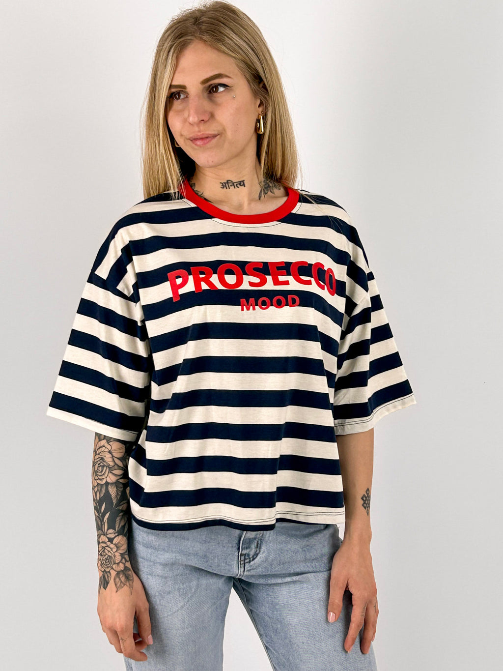T-shirt Prosecco da donna a righe con stampa frontale indossata con jeans chiari. vista frontale