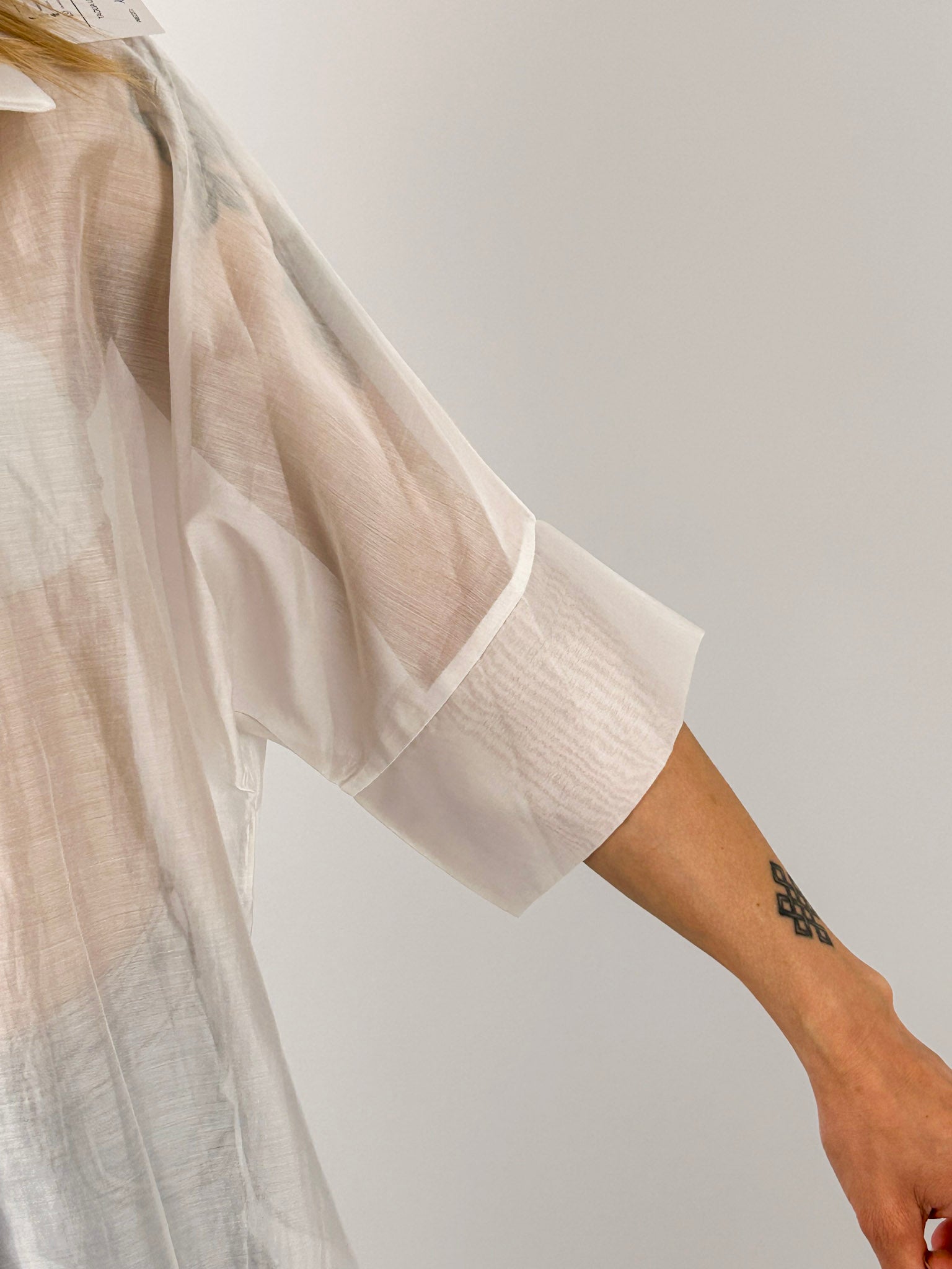Camicia Nora da donna leggera effetto vedo-non-vedo indossata con jeans chiari. bianca dettaglio manica