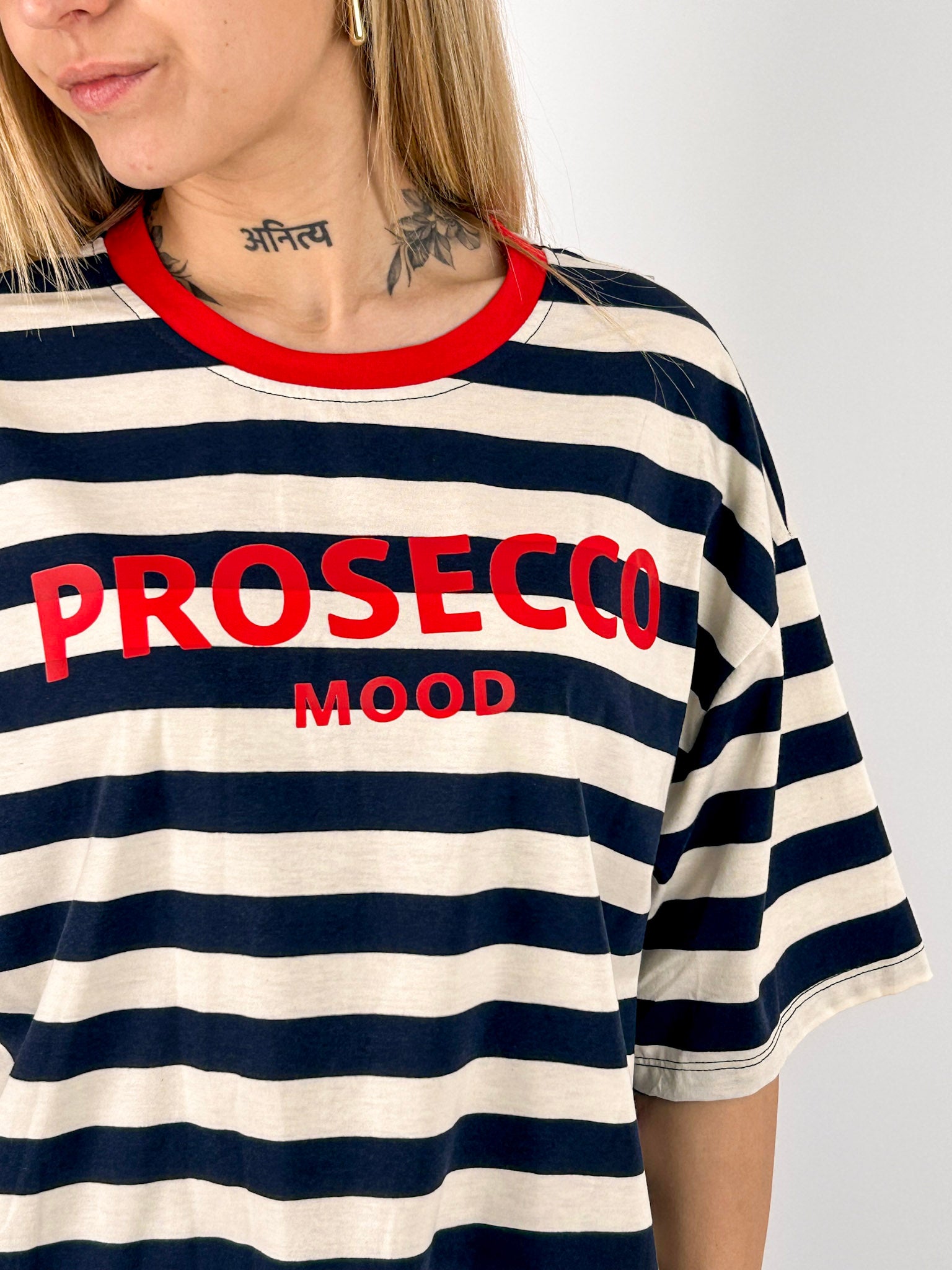 T-shirt Prosecco da donna a righe con stampa frontale indossata con jeans chiari. dettaglio tessuto