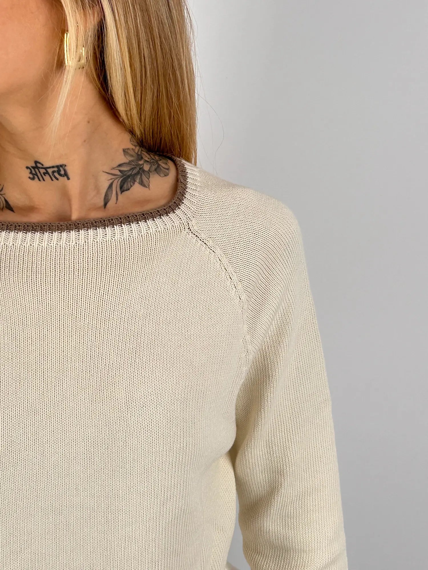 Maglia donna panna in cotone con dettagli marroni sui bordi indossata con jeans chiari. vista dettaglio collo