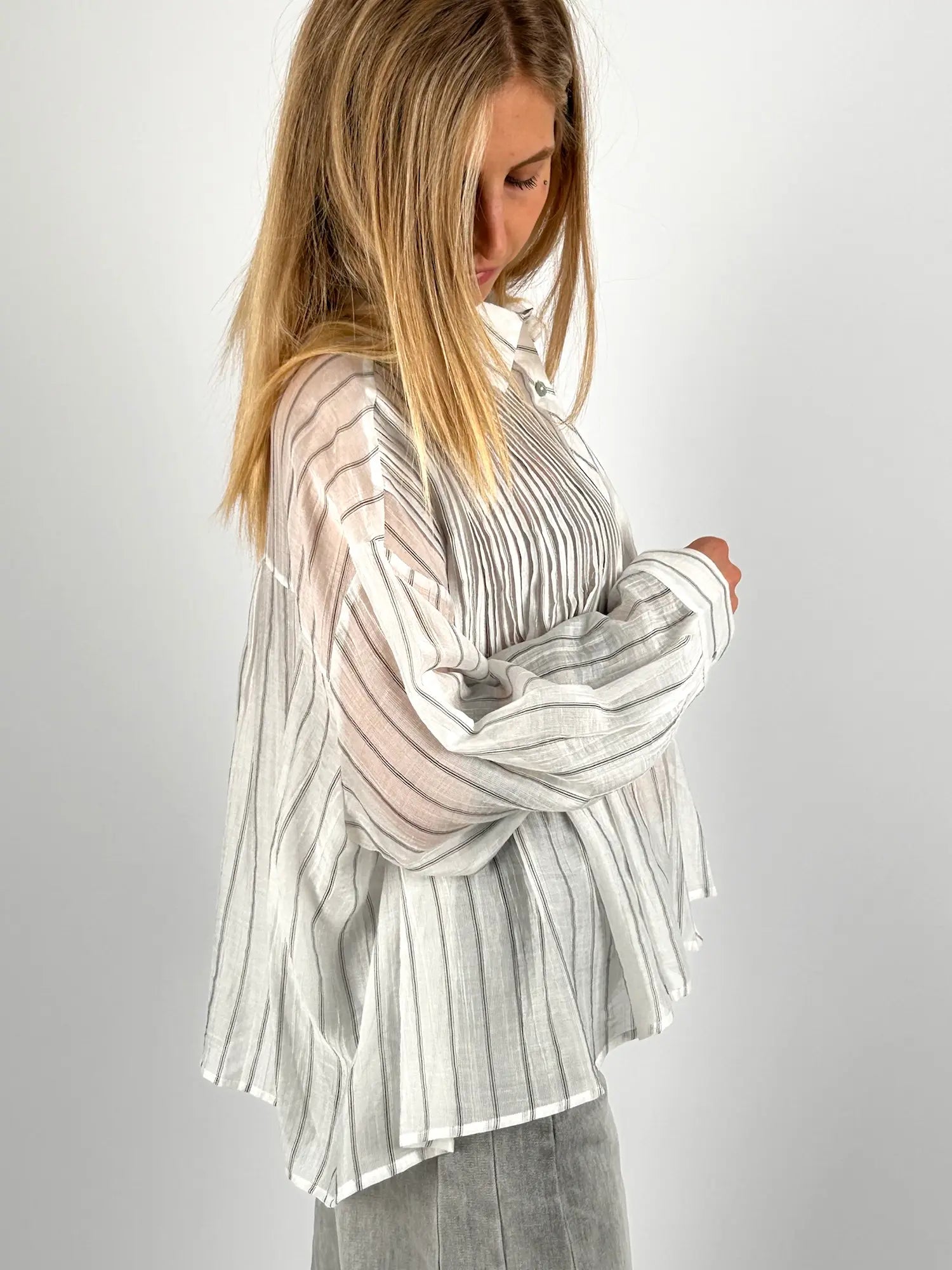 Camicia donna plissé a righe nei toni beige e grigio con vestibilità morbida e tessuto leggero. vista manica