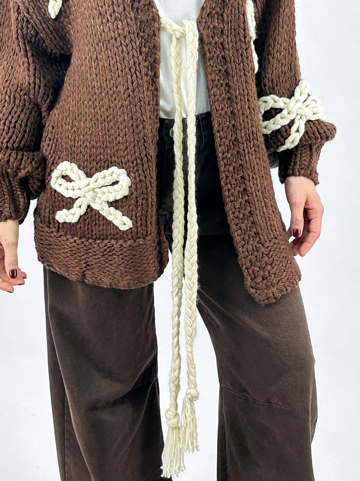 Cardigan donna in maglia con fiocchi applicati e chiusura con laccio marrone - vista laccio