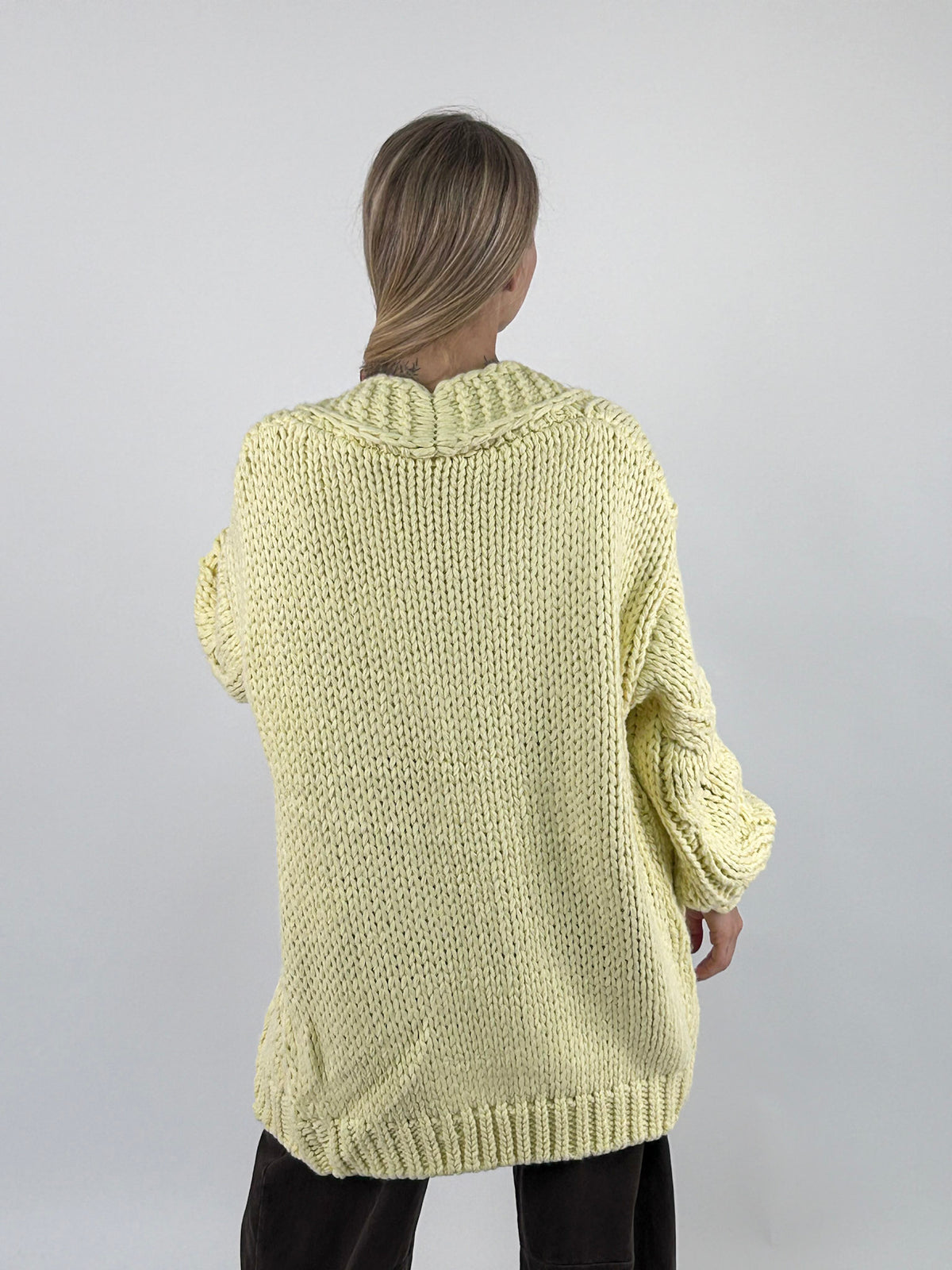Cardigan donna lungo in maglia grossa con lavorazione a trecce e spalla scesa giallo - vista retro