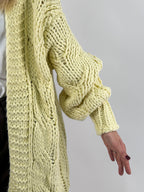 Cardigan donna lungo in maglia grossa con lavorazione a trecce e spalla scesa giallo - vista dettaglio manica