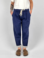 Pantalone donna blu chiaro con vita elastica e dettaglio ricamato sul fondo indossato con sabot marroni