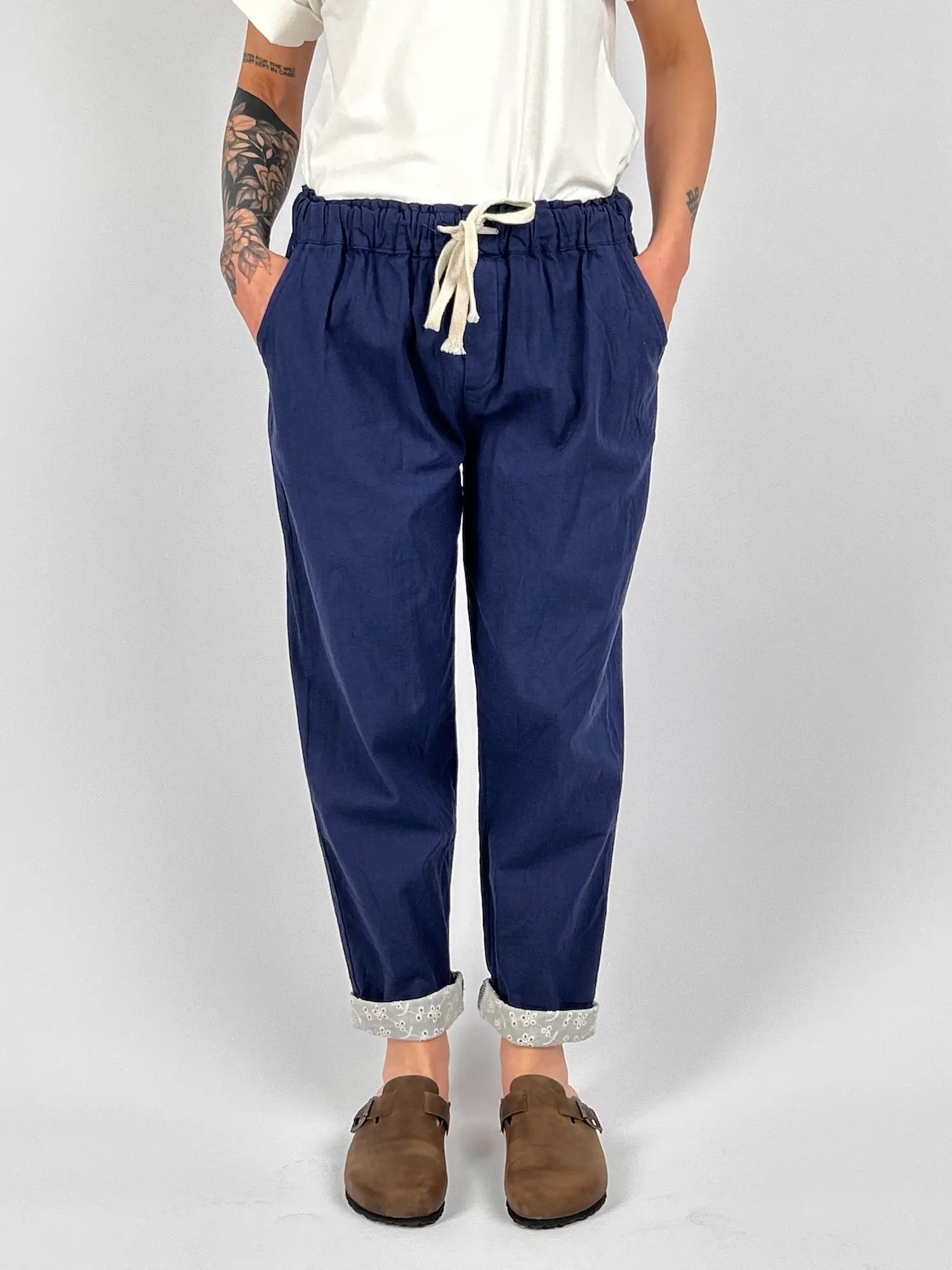 Pantalone donna blu chiaro con vita elastica e dettaglio ricamato sul fondo indossato con sabot marroni