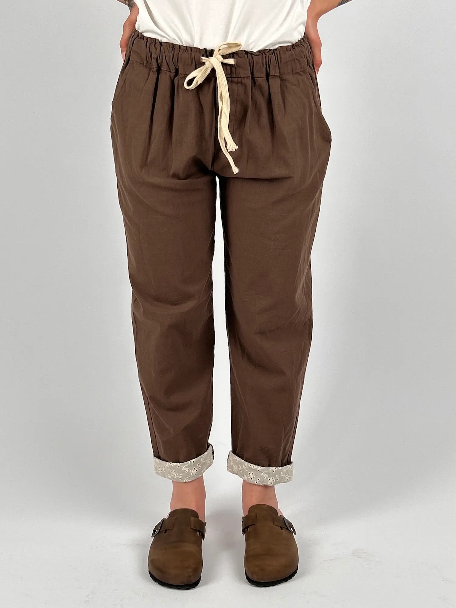 Pantalone donna cioccolato con vita elastica e dettaglio ricamato sul fondo indossato con sabot marroni