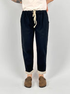 Pantalone donna nero con vita elastica e dettaglio ricamato sul fondo indossato con sabot marroni
