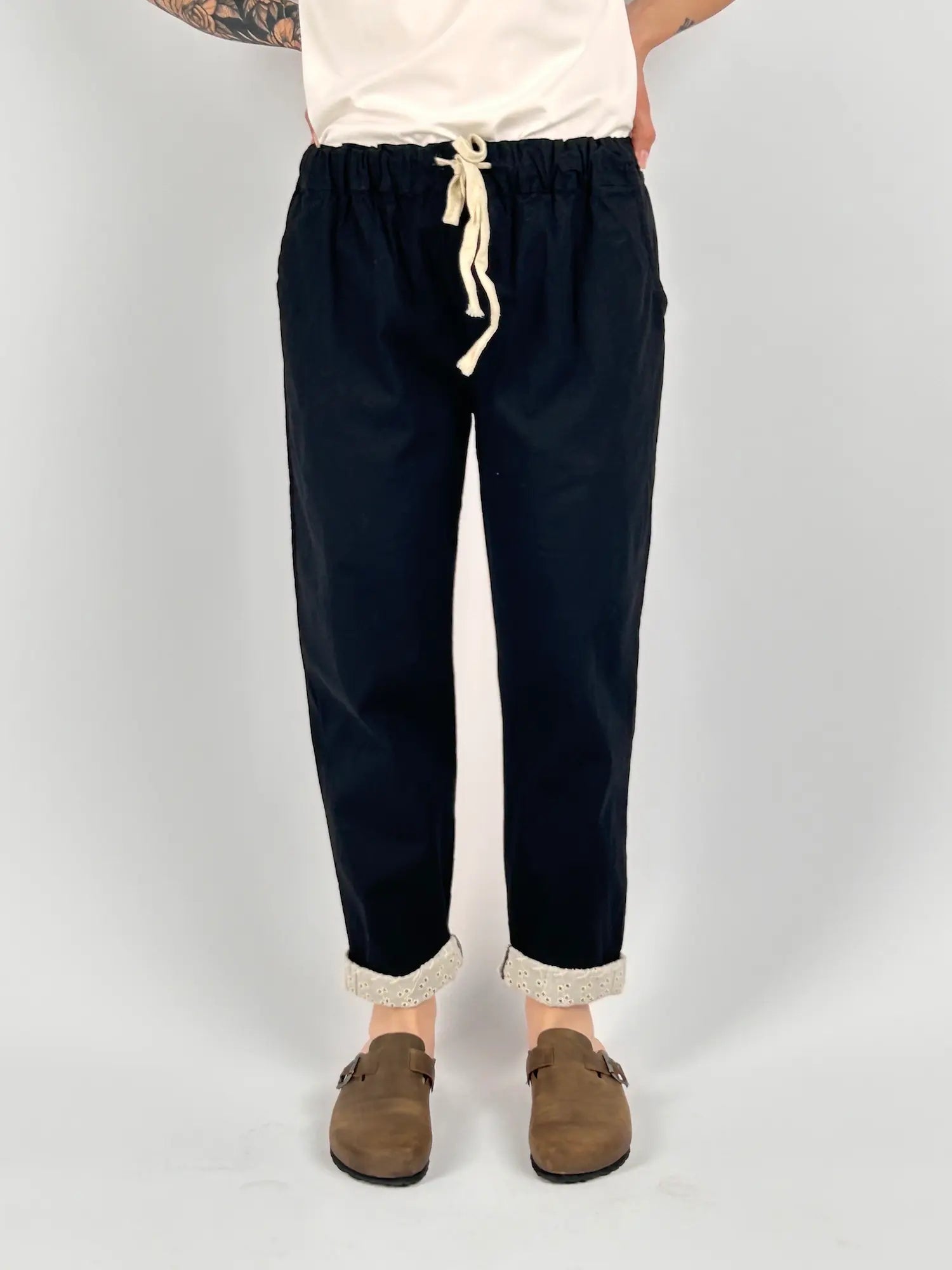 Pantalone donna blu con vita elastica e dettaglio ricamato sul fondo indossato con sabot marroni