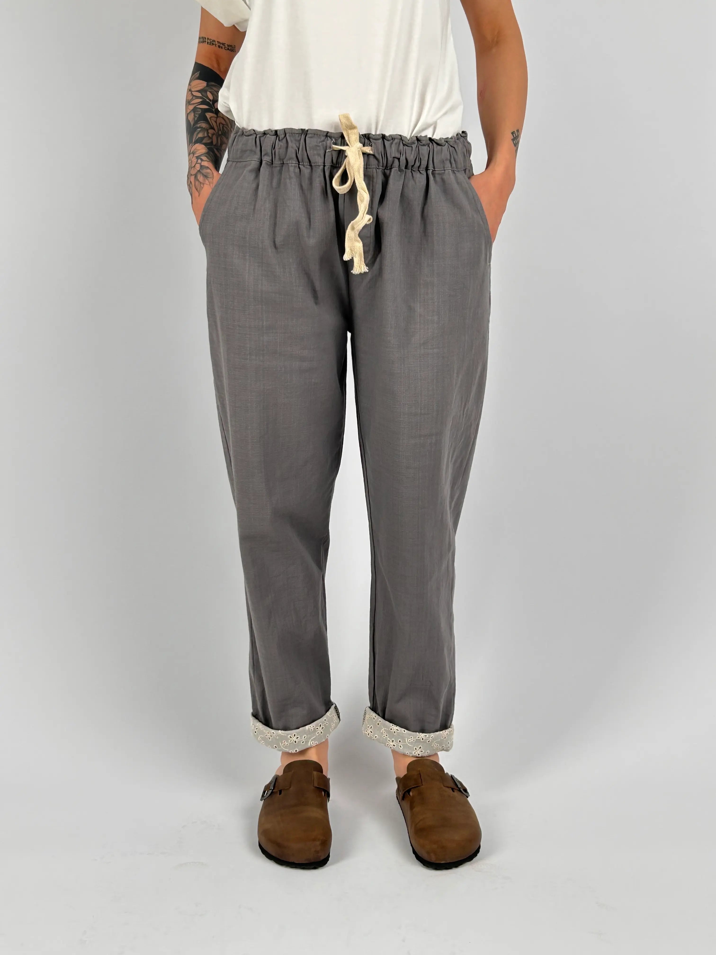 Pantalone donna grigio con vita elastica e dettaglio ricamato sul fondo indossato con sabot marroni