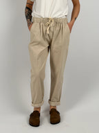 Pantalone donna panna con vita elastica e dettaglio ricamato sul fondo indossato con sabot marroni