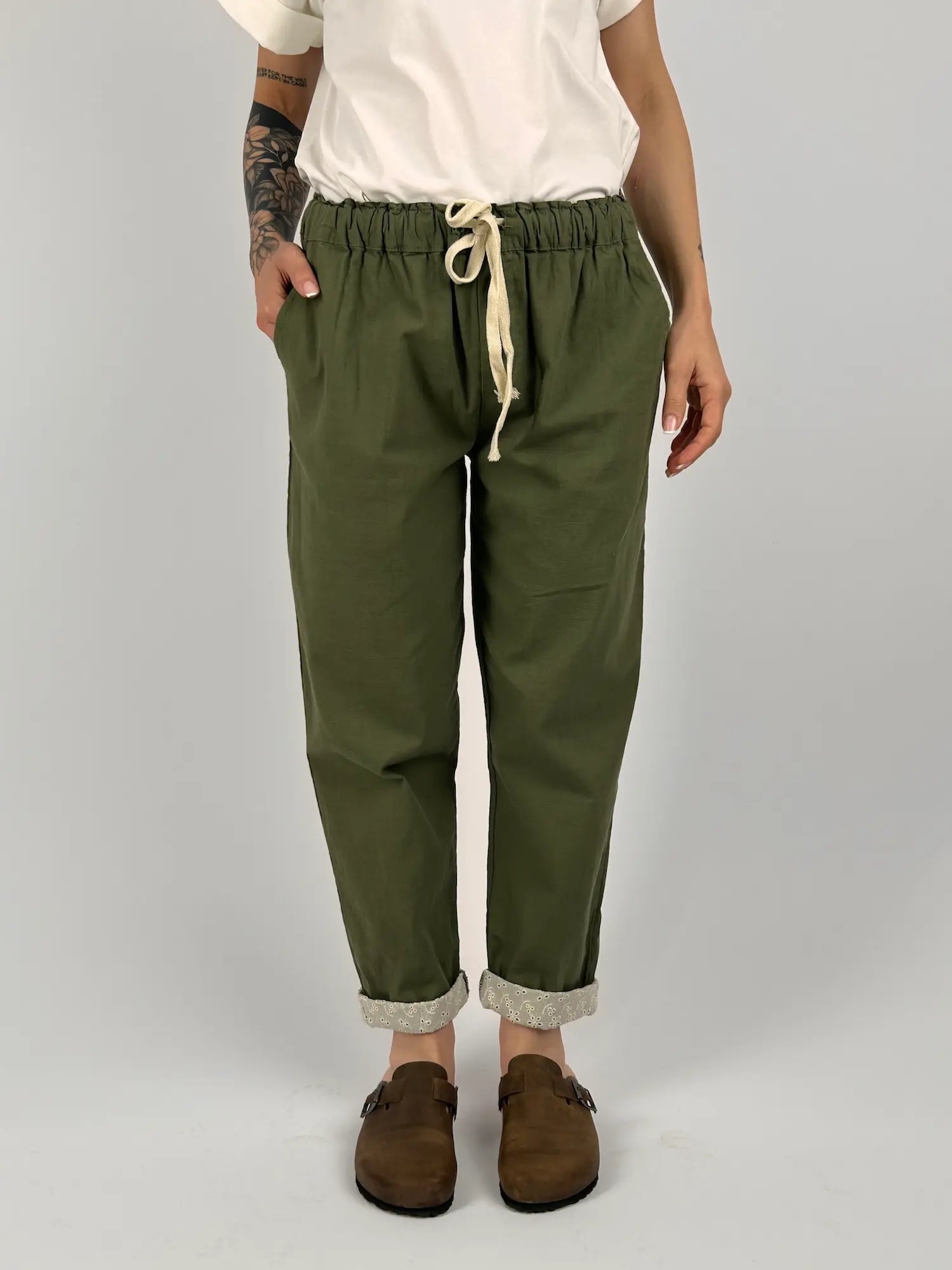 Pantalone donna verde con vita elastica e dettaglio ricamato sul fondo indossato con sabot marroni
