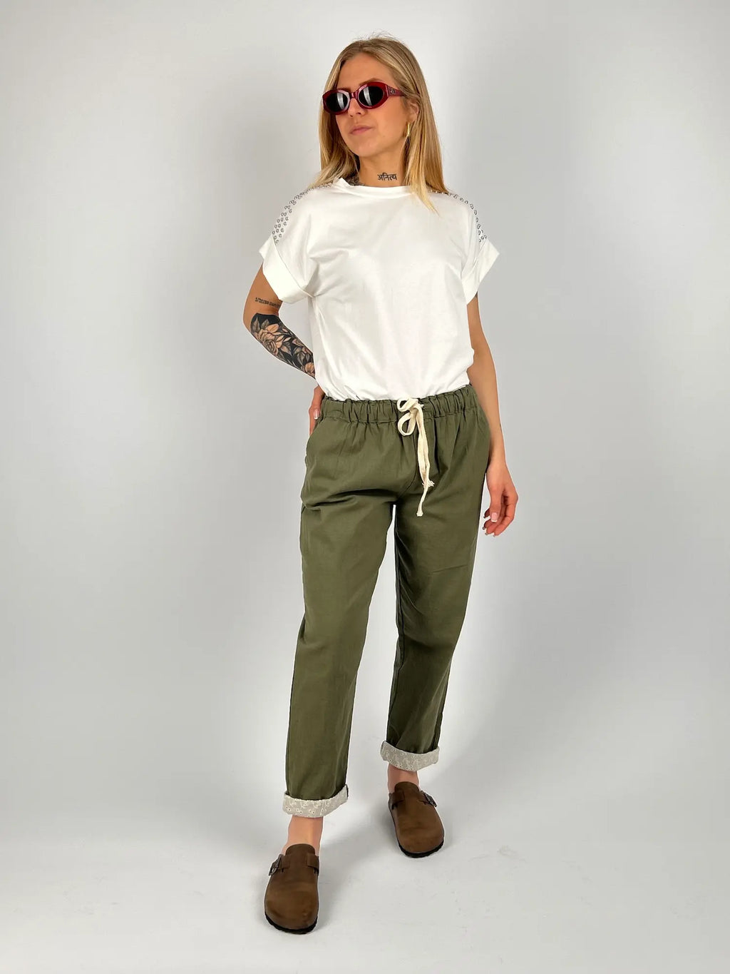 Pantalone donna verde militare con vita elastica e dettaglio ricamato sul fondo indossato con sabot marroni.. outfit