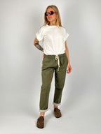 Pantalone donna verde militare con vita elastica e dettaglio ricamato sul fondo indossato con sabot marroni.. outfit