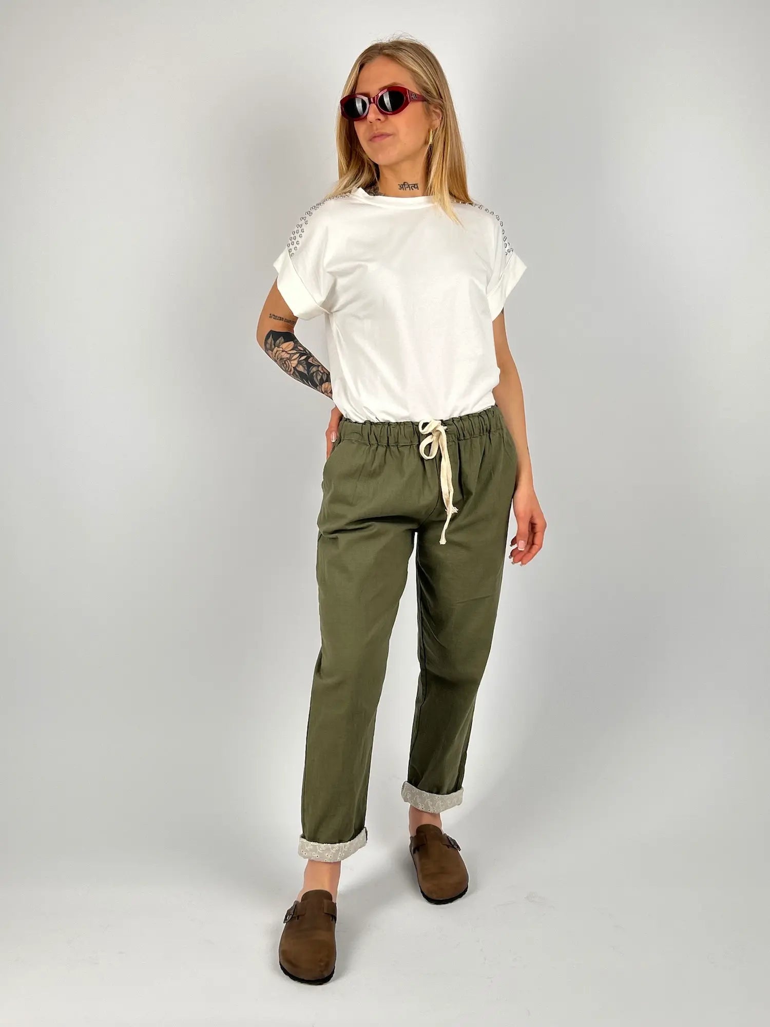 Pantalone donna verde con vita elastica e dettaglio ricamato sul fondo indossato con sabot marroni.. outfit