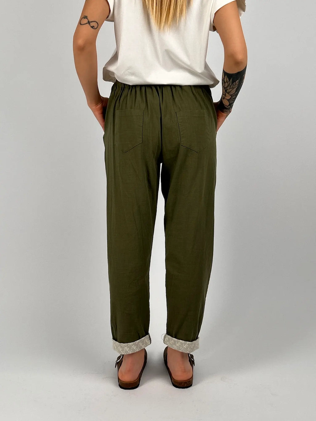 Pantalone donna verde militare con vita elastica e dettaglio ricamato sul fondo indossato con sabot marroni. vista retro