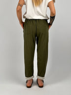 Pantalone donna verde militare con vita elastica e dettaglio ricamato sul fondo indossato con sabot marroni. vista retro