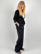 Completo donna nero con blazer elegante e pantalone ampio a vita alta stile chic moderno. 