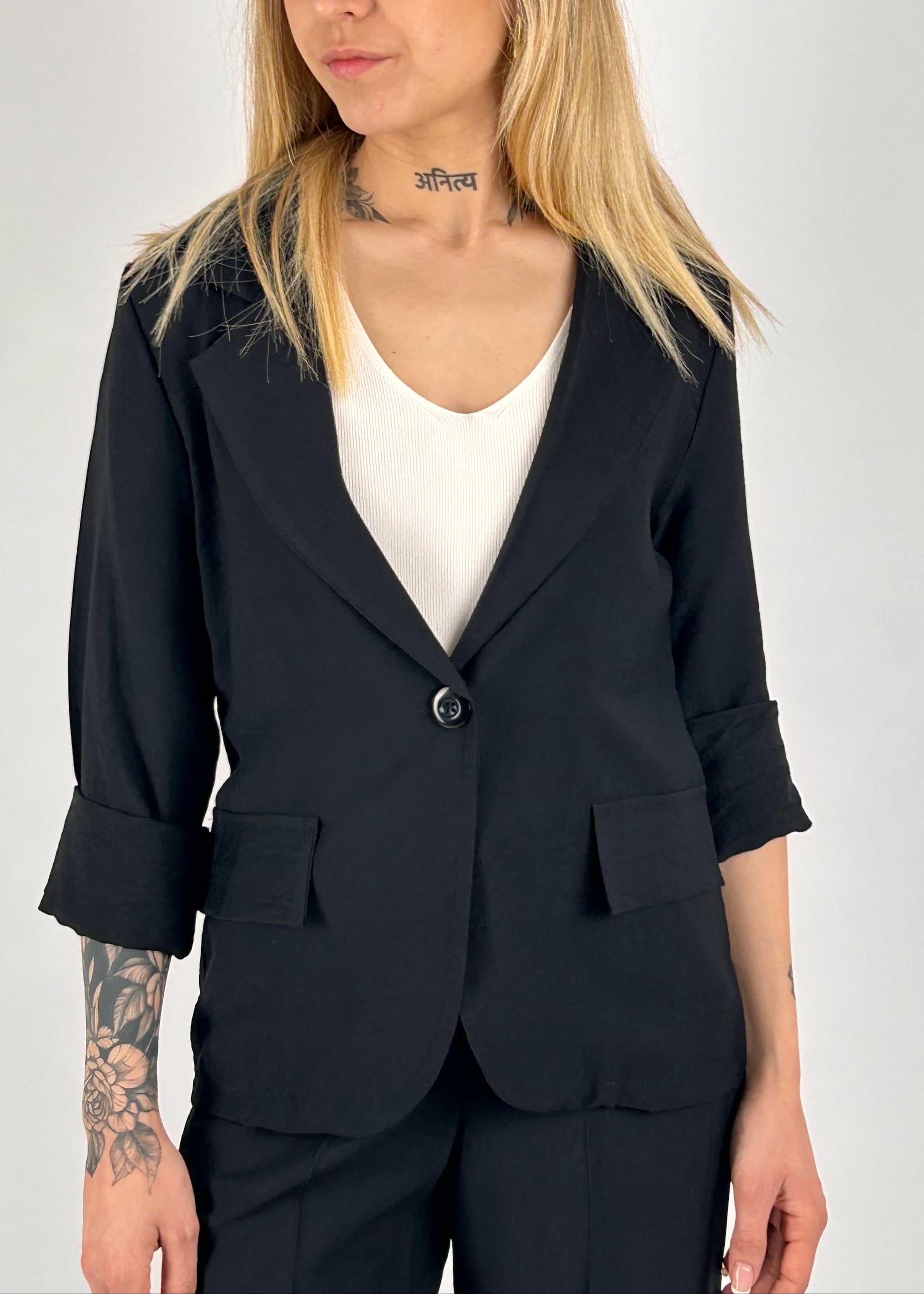 Completo donna nero con blazer elegante e pantalone ampio a vita alta stile chic moderno. vista giacca