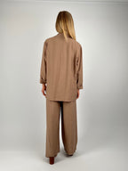 Completo donna beige con giacca aperta morbida e pantalone ampio stile elegante rilassato. vista retro