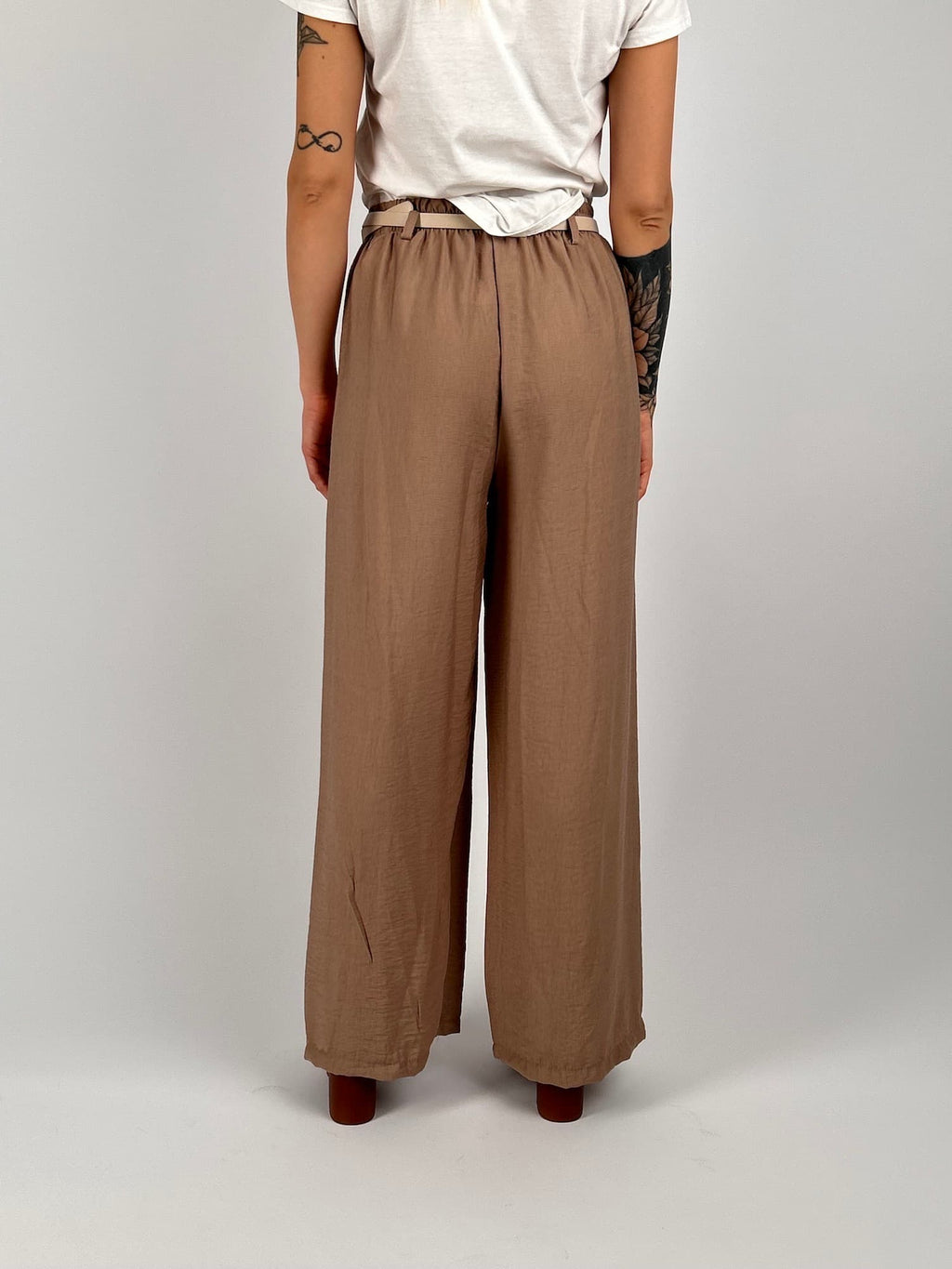 Completo donna beige con giacca aperta morbida e pantalone ampio stile elegante rilassato. vista retro pantalone
