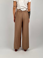 Completo donna beige con giacca aperta morbida e pantalone ampio stile elegante rilassato. vista retro pantalone