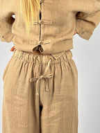 Completo donna in lino beige con pantalone ampio e casacca morbida. dettaglio pantalone