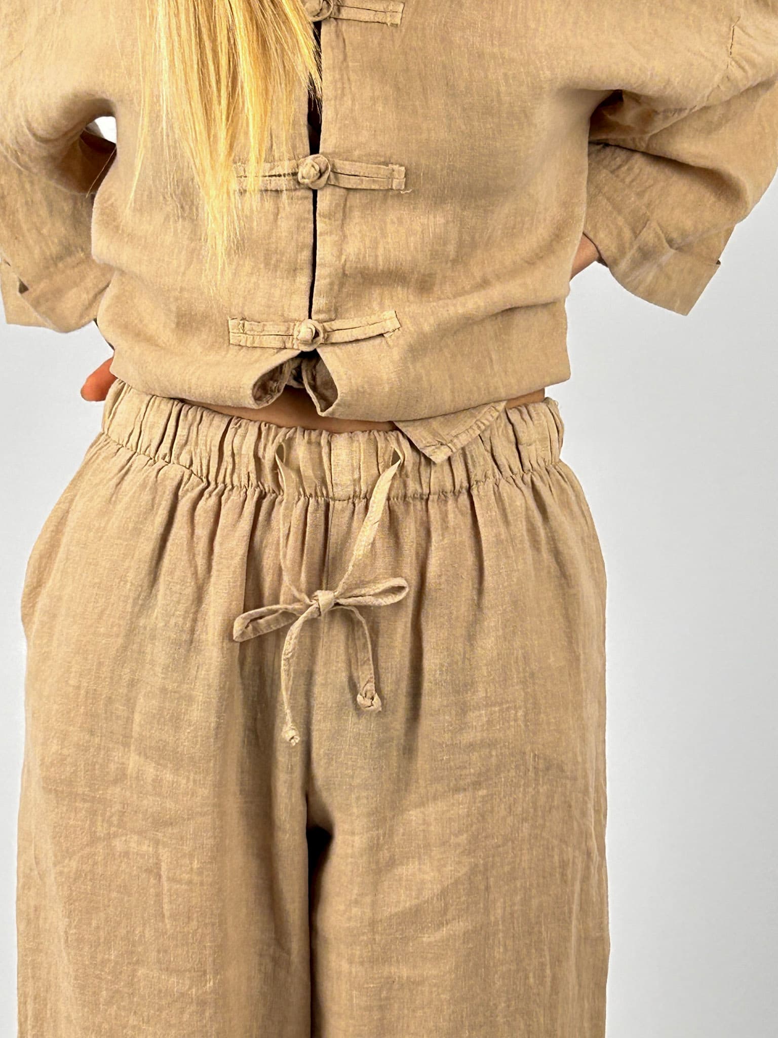 Completo donna in lino beige con pantalone ampio e casacca morbida. dettaglio pantalone