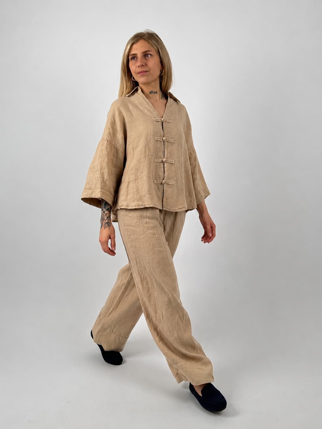 Completo donna in lino beige con pantalone ampio e casacca morbida. modella in posa