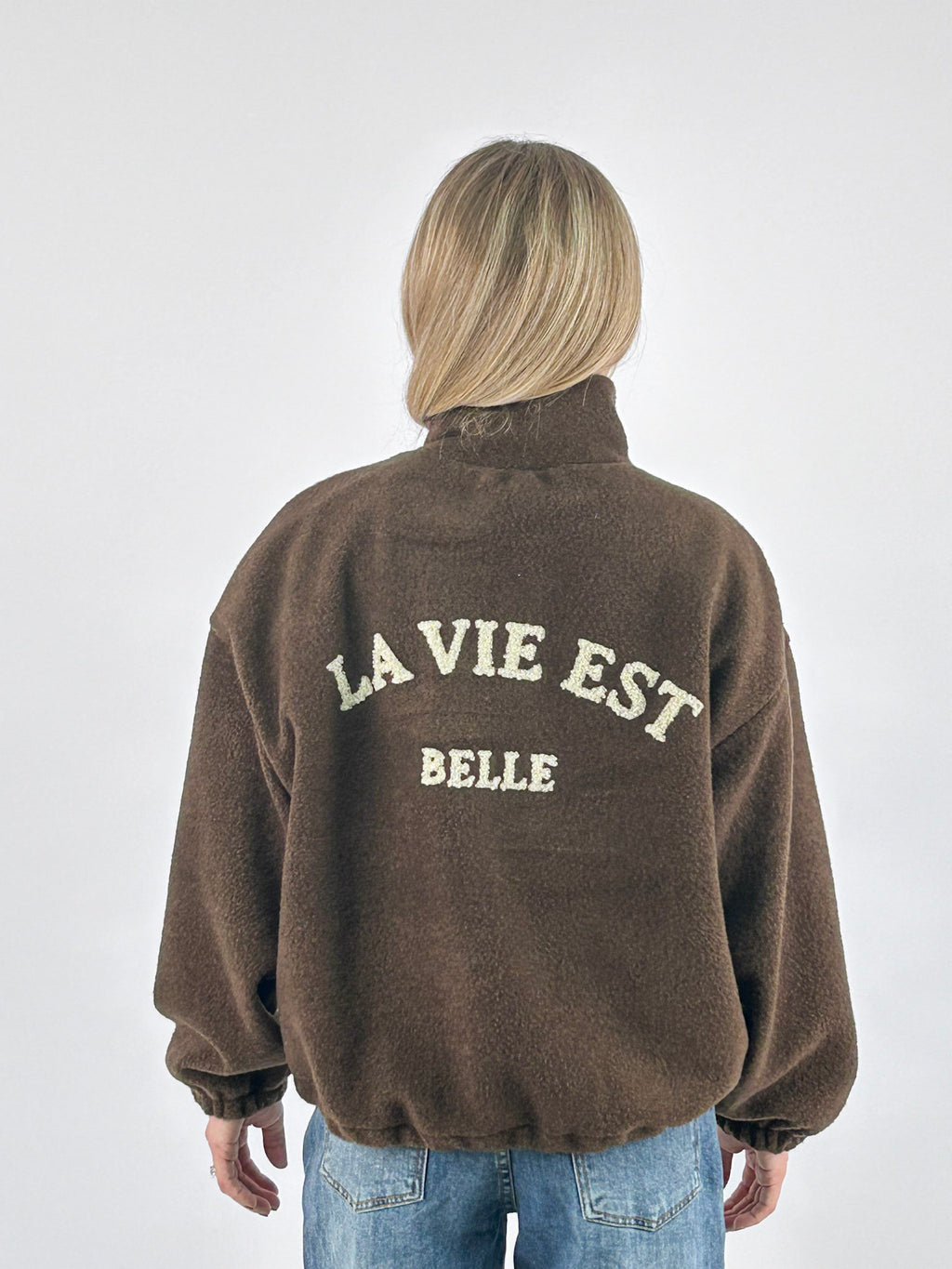 Giubbino donna con zip e collo alto con scritta La vie est belle sul retro marrone - vista retro