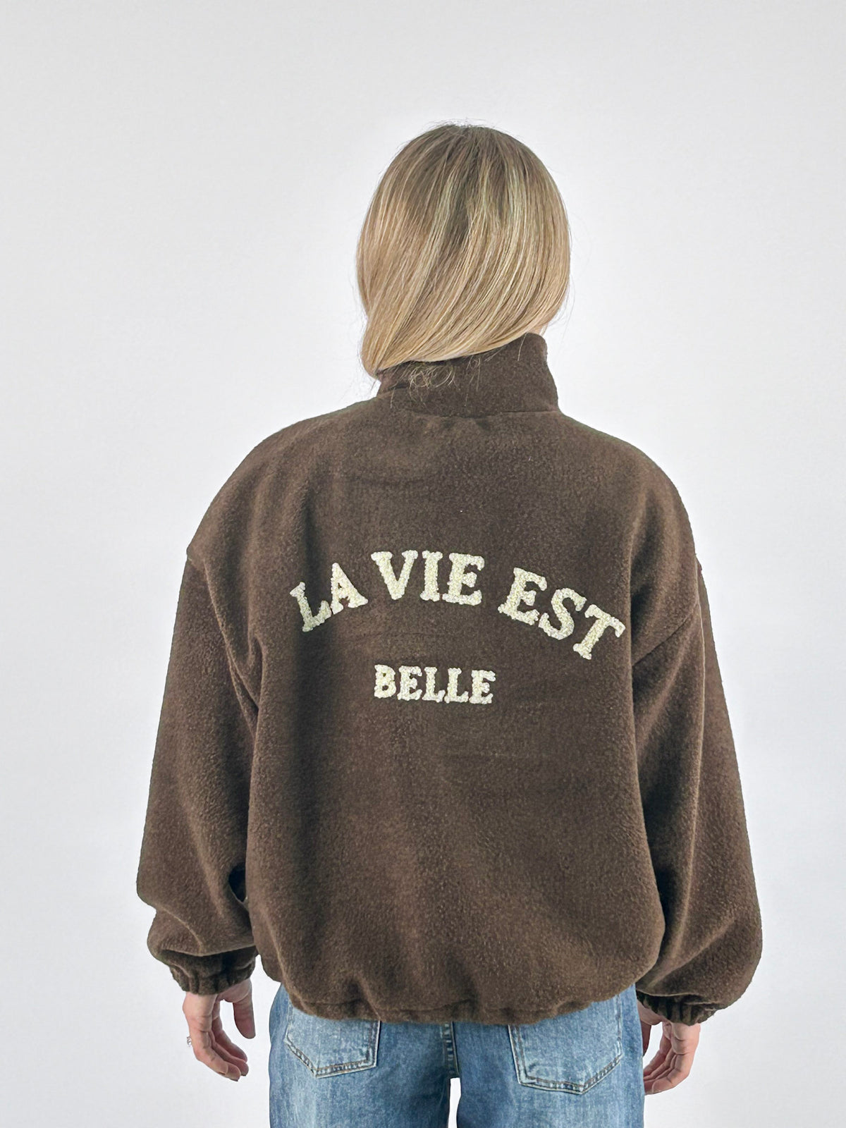 Giubbino donna con zip e collo alto con scritta La vie est belle sul retro marrone - vista retro