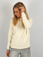 Maglia donna panna in cotone con dettagli marroni sui bordi indossata con jeans chiari.vista frontale