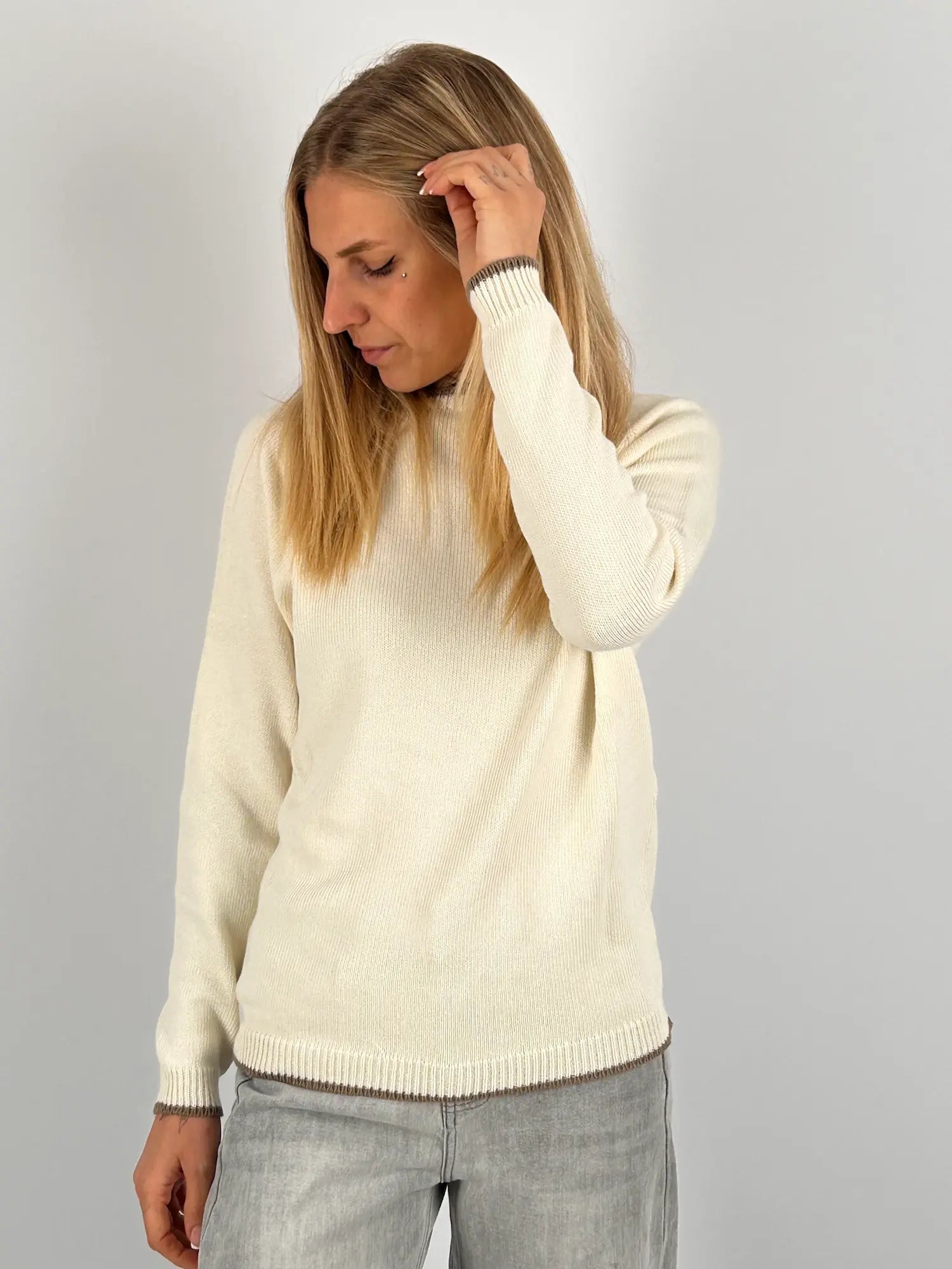 Maglia donna panna in cotone con dettagli marroni sui bordi indossata con jeans chiari.vista frontale