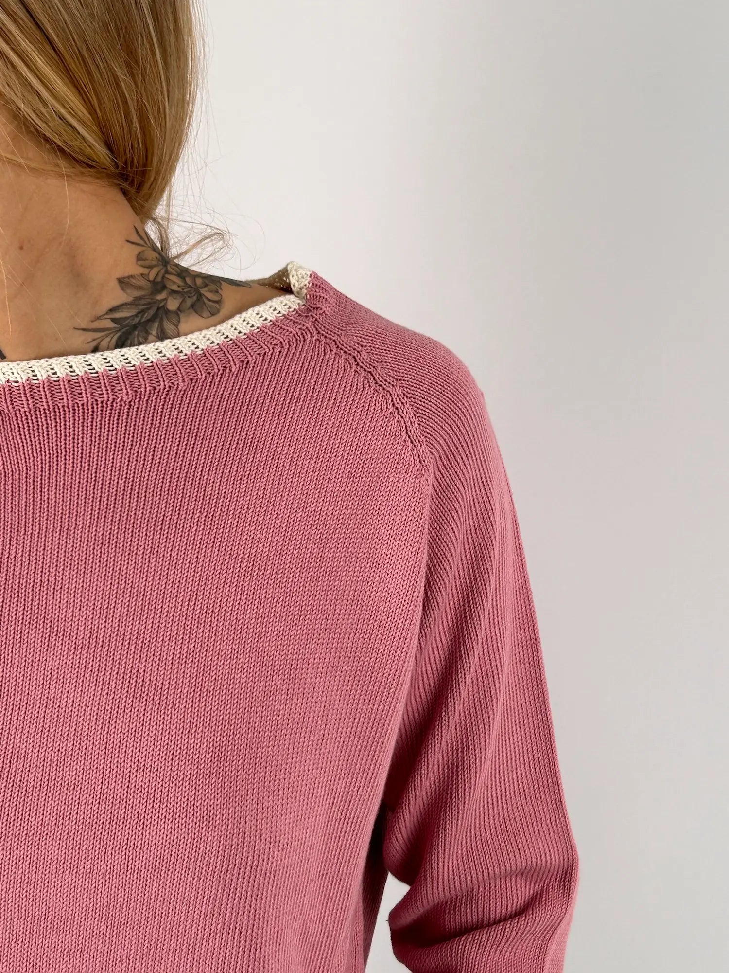 Maglia donna rosa in cotone con dettagli marroni sui bordi indossata con jeans chiari. vista dettaglio
