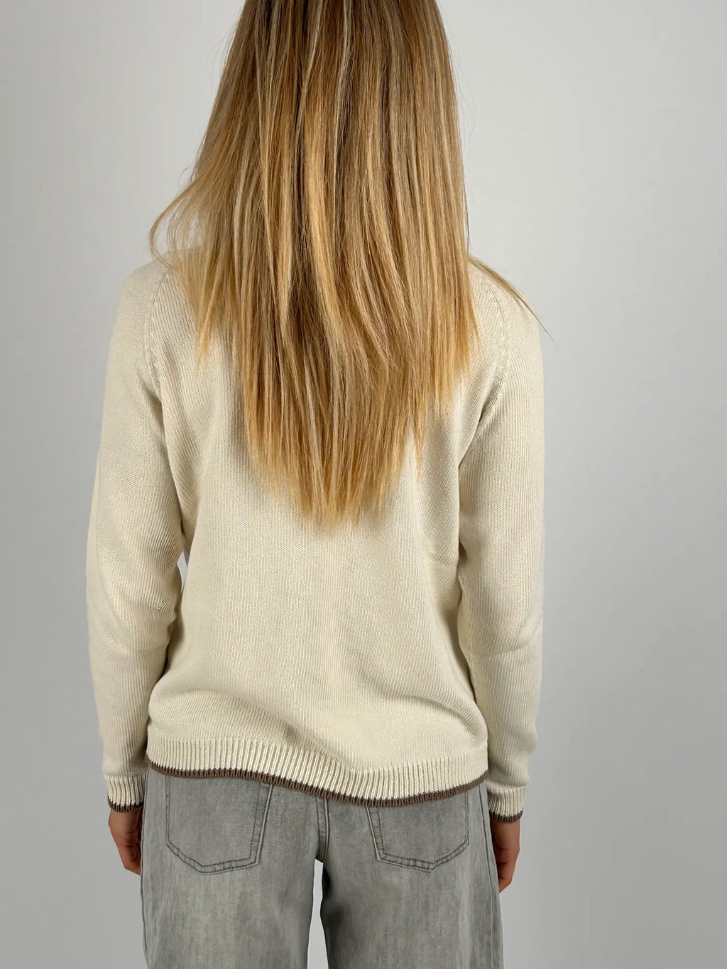 Maglia donna panna in cotone con dettagli marroni sui bordi indossata con jeans chiari.vista retro