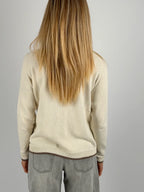 Maglia donna panna in cotone con dettagli marroni sui bordi indossata con jeans chiari.vista retro