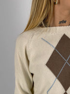 Maglia donna rosa con fantasia a rombi marroni e azzurri indossata con jeans chiari. dettaglio tessuto