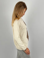 Maglia donna rosa con fantasia a rombi marroni e azzurri indossata con jeans chiari.vista laterale