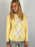 Maglia donna giallo con fantasia a rombi marroni e azzurri indossata con jeans chiari.vista frontale