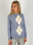 Maglia donna azzurro con fantasia a rombi marroni e azzurri indossata con jeans chiari.vista frontale