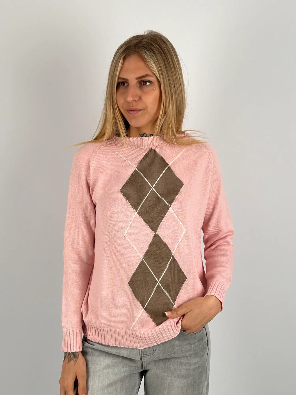 Maglia donna rosa con fantasia a rombi marroni e azzurri indossata con jeans chiari.vista frontale