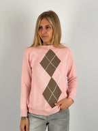 Maglia donna rosa con fantasia a rombi marroni e azzurri indossata con jeans chiari.vista frontale
