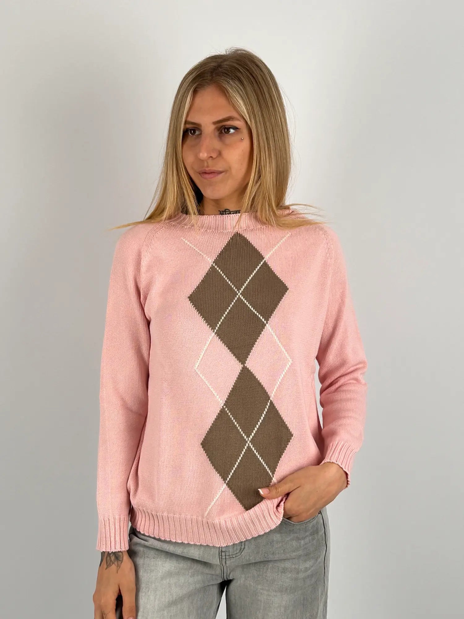 Maglia donna rosa con fantasia a rombi marroni e azzurri indossata con jeans chiari.vista frontale
