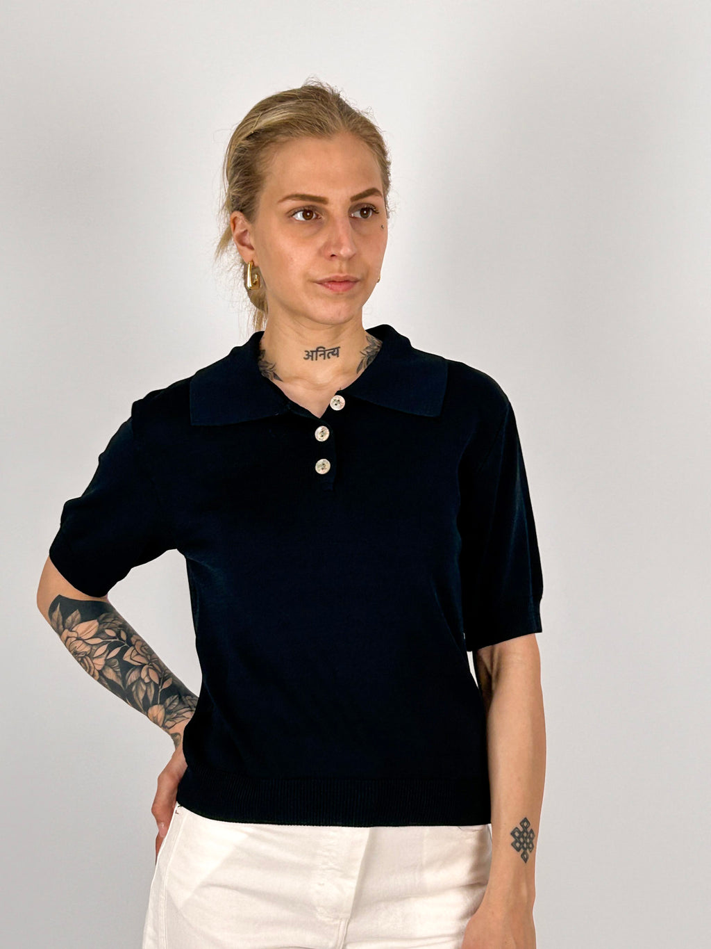 Polo donna in maglia nero con colletto classico e bottoni frontali - vista frontale