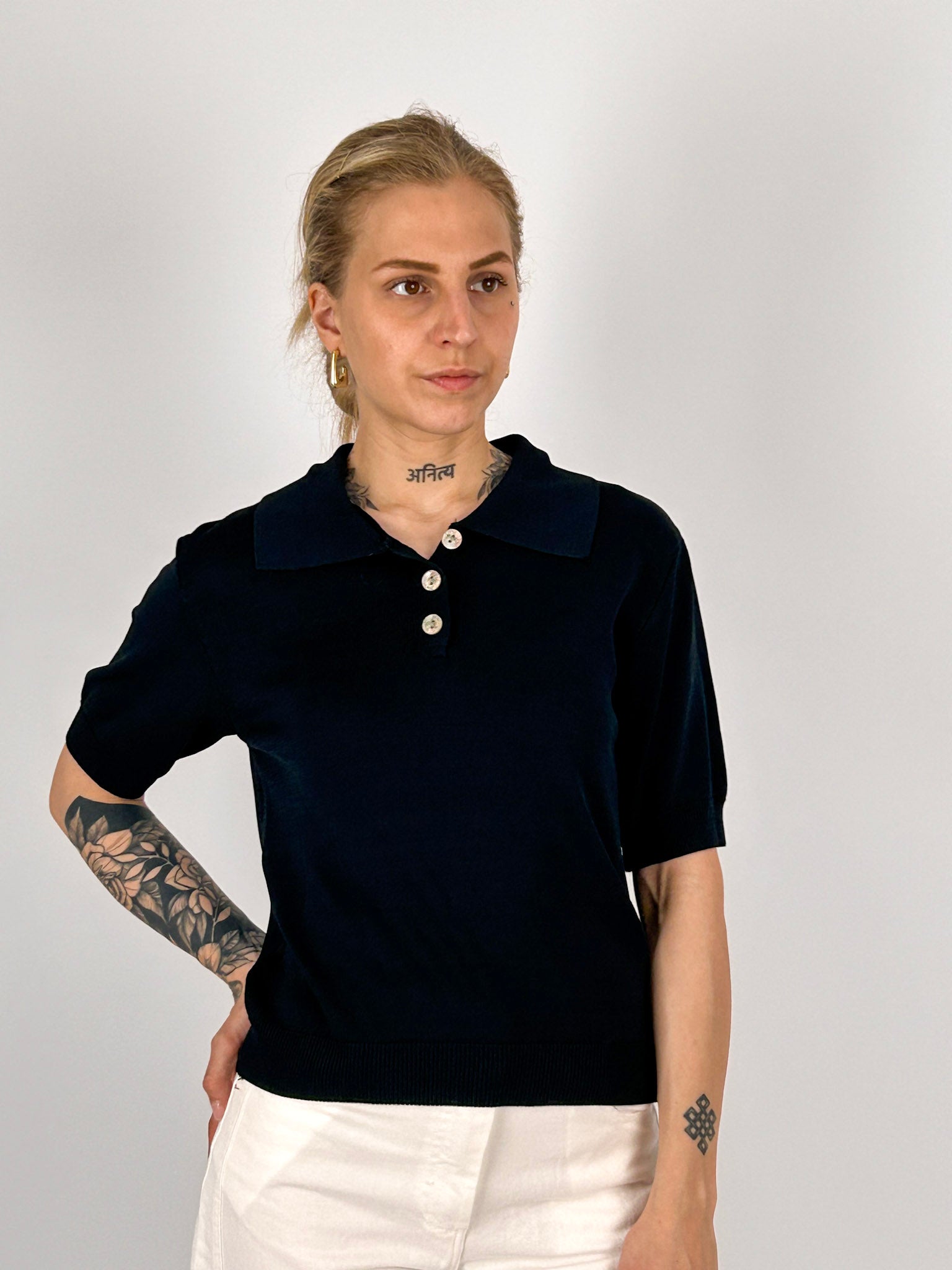 Polo donna in maglia nero con colletto classico e bottoni frontali - vista frontale