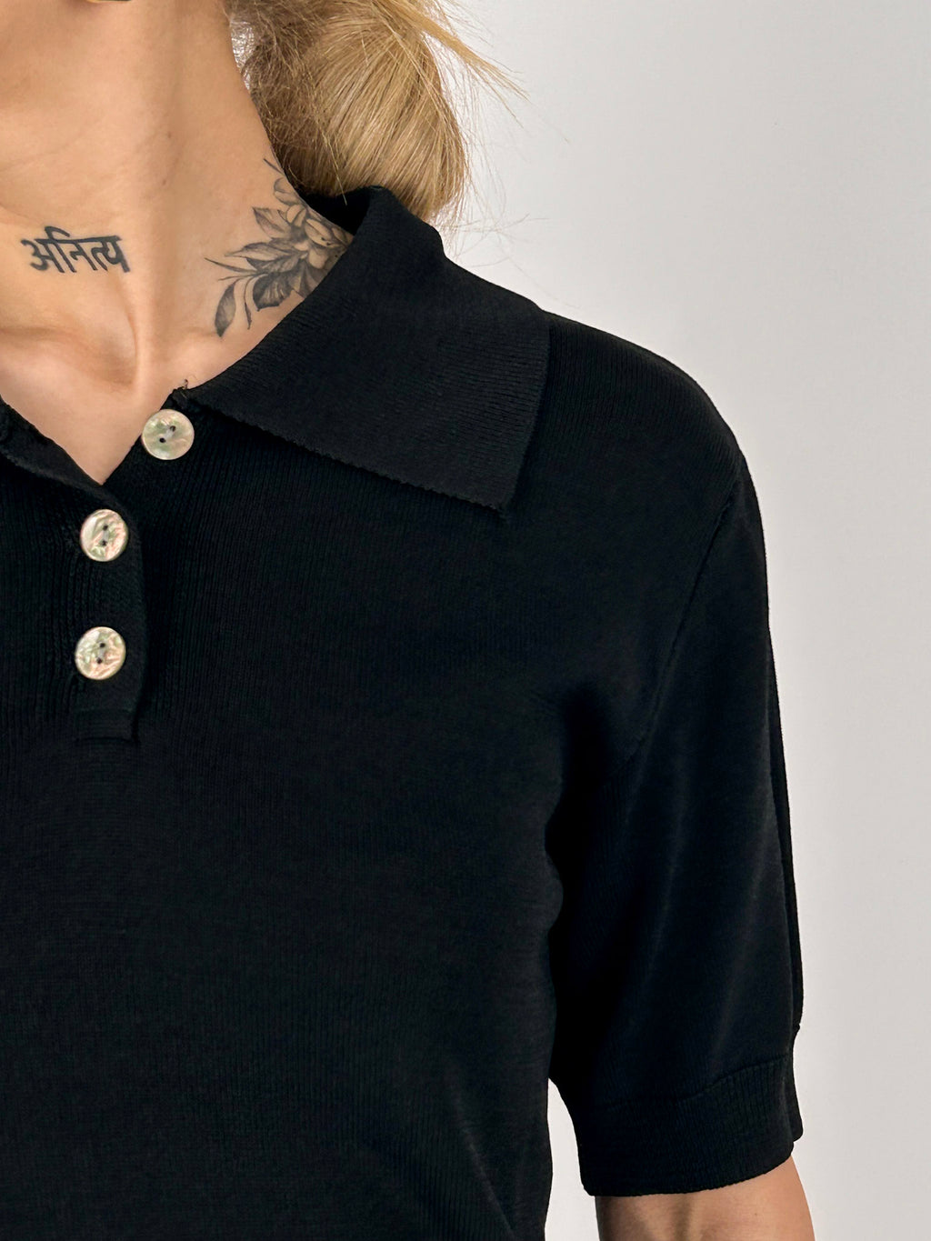 Polo donna in maglia nero con colletto classico e bottoni frontali - vista dettaglio