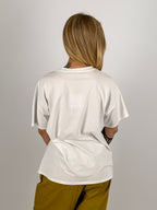 T-shirt donna bianca in cotone nero con grande applicazione floreale nera sul davanti - vista retro