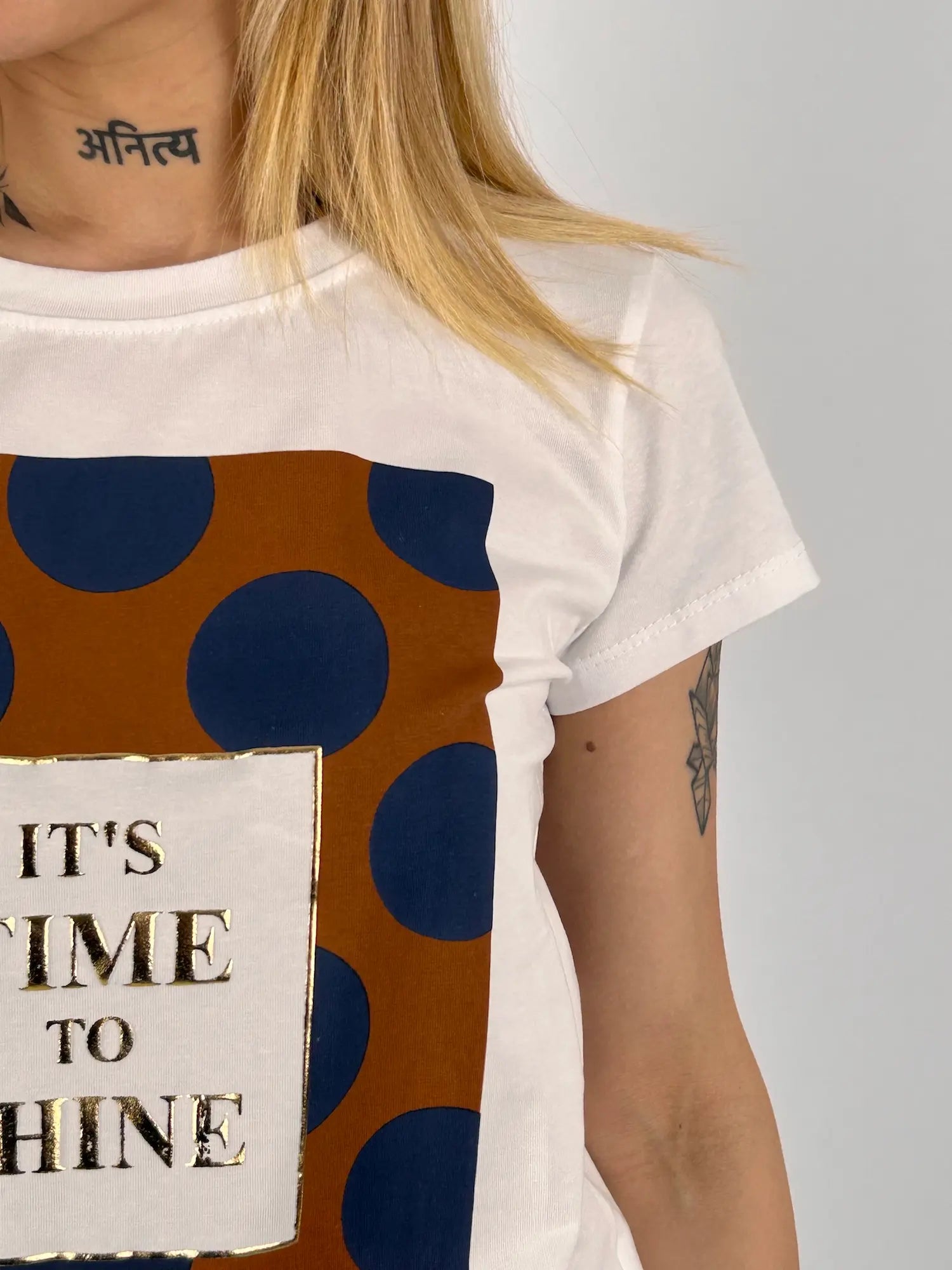 T-shirt donna bianca con stampa grafica a pois blu e scritta It’s Time To Shine stile casual moderno. vista dettaglio