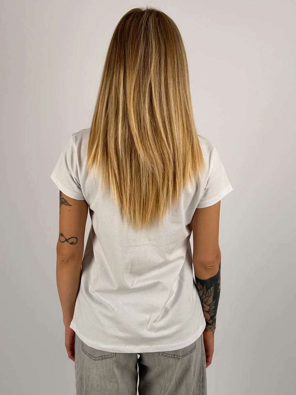 T-shirt donna bianca con stampa grafica a pois blu e scritta It’s Time To Shine stile casual moderno. vista retro