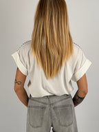 T-shirt donna bianco con micro borchie decorative sulle spalle e vestibilità morbida stile casual chic. vista retro